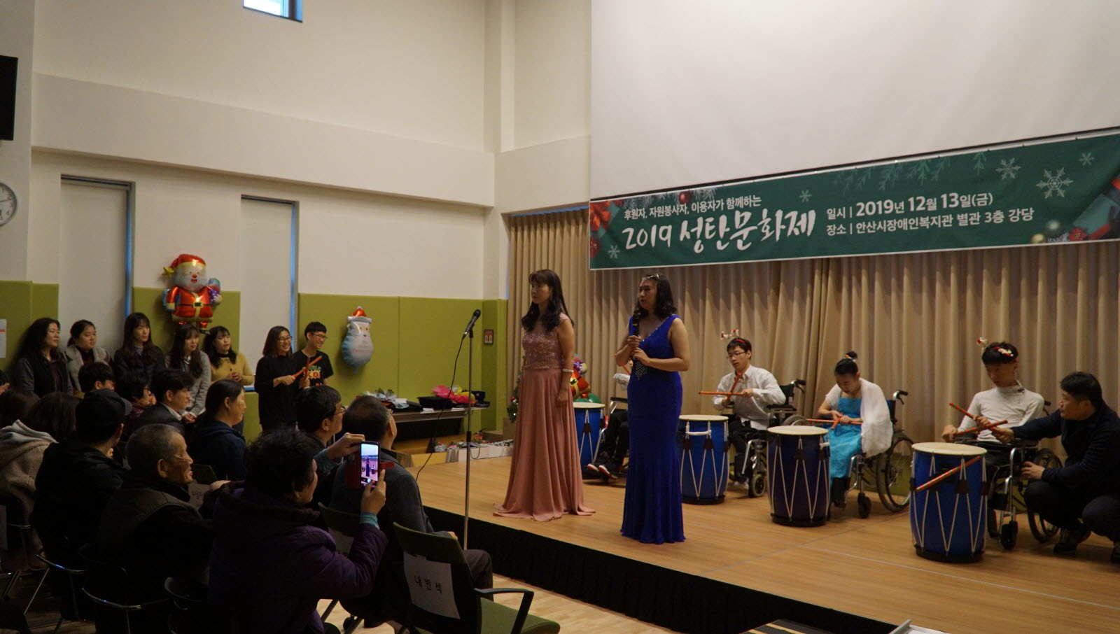 주간보호시설 대체인력, 자원봉사자, 이용자가 함께하는 노래와 난타 공연을 하고 있는 모습